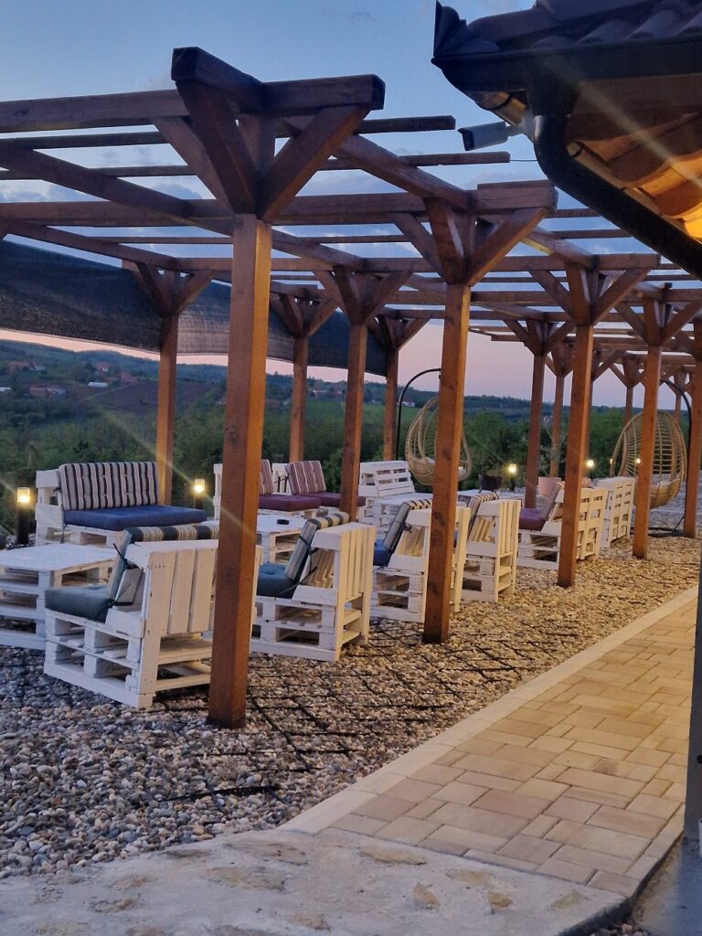 Baštenski nameštaj i stolice pod osvetljenom terasom za večernji odmor.