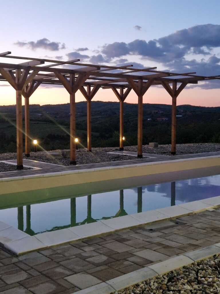Romantičan ambijent pored bazena u sumrak u srcu Šumadije.