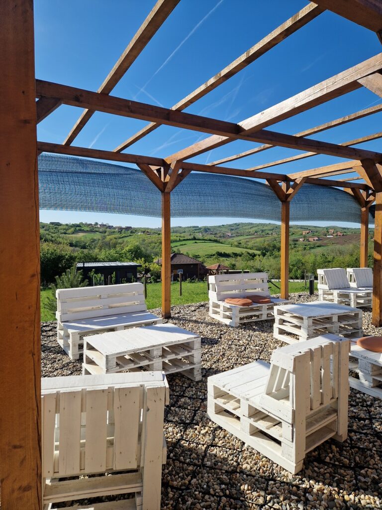 Uređena terasa sa cvećem i pogledom na imanje za izdavanje u Šumadiji.